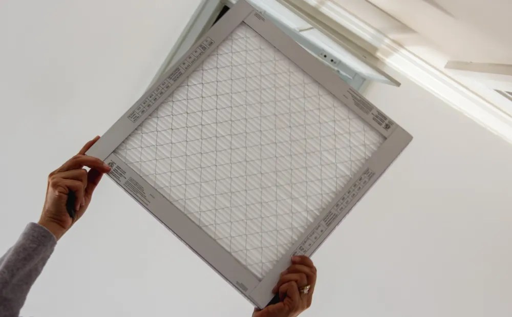Identifying poor air quality in your Hermiston home - Person changing vent filter.