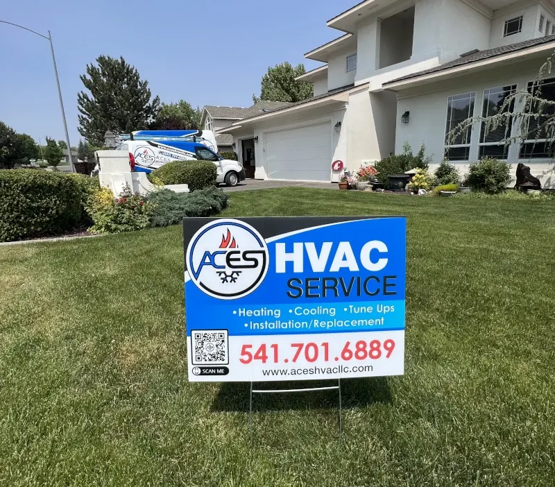 Blue ACES Heating & Cooling service sign in a yard with a white van and a house in the background.